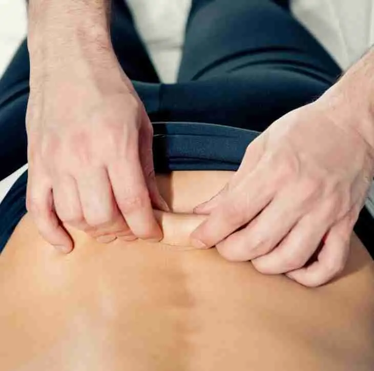 Myofascial Stretching, skin rolling on a patients back