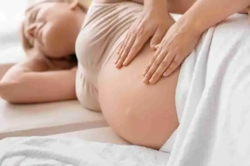 Pre-natal massage therapy session, woman on massage table
